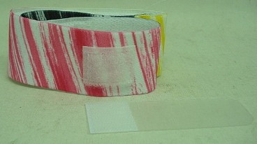Stirnband m. Klett-Augenklappe - schwarz/rot/gelb auf weiß
